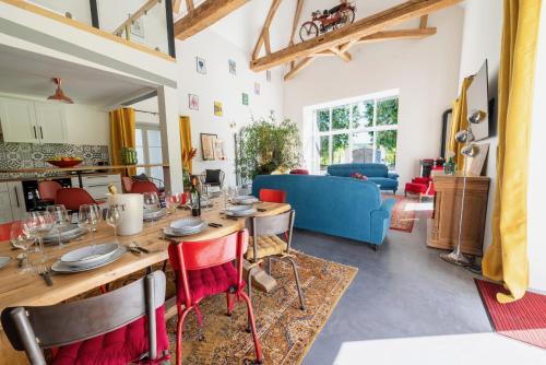 a dining room and living room with a table and chairs at Le Domaine d'Ailleurs in Cohan