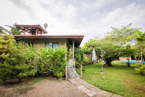 a house with a garden and an umbrella at Mass Eco Cabana by Ruby in Talpe