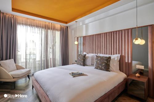 a hotel room with a large bed and a chair at Stayhere Rabat - Agdal 4 - Hotel in Rabat