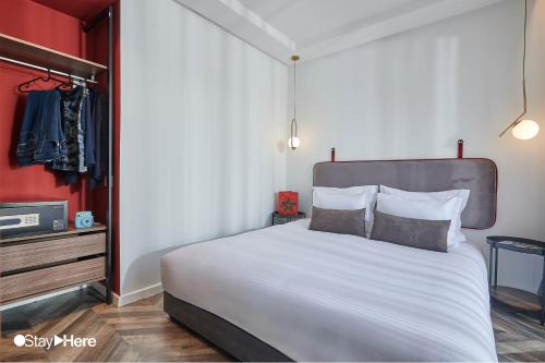 a bedroom with a large bed and a red wall at Stayhere Rabat - Agdal 4 - Hotel in Rabat