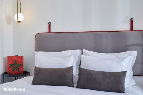 a bed with white pillows and a silver headboard at Stayhere Rabat - Agdal 4 - Hotel in Rabat
