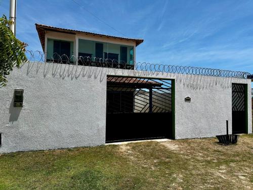 a white building with a black door and a balcony at Caminho do Mar in Prado
