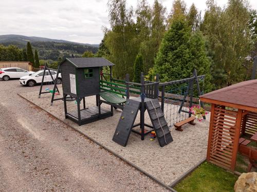a playground with a bench and a play structure at Domek drewniany w górach Jacuzzi & Balia - Osada Chełm in Stróża
