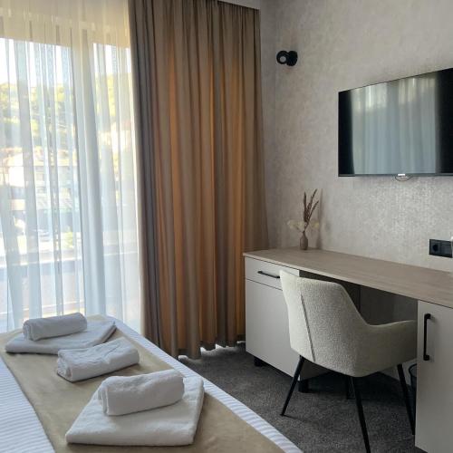 a hotel room with a desk and a television at Zlate Home in Zlatograd