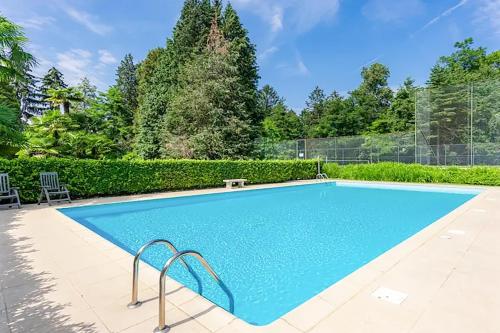 a swimming pool with blue water in a yard at Panorama e Relax in Germignaga