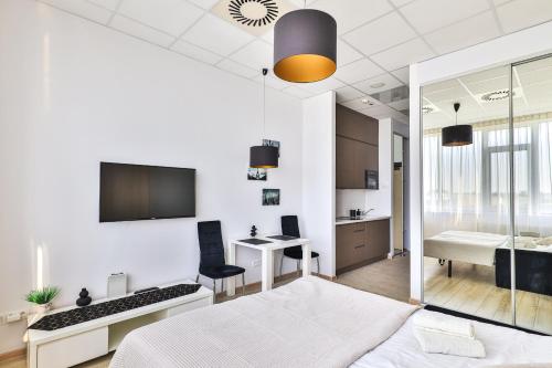 a bedroom with a bed and a desk and a television at Aleje Jerozolimskie 216 By Perfect Apart in Warsaw