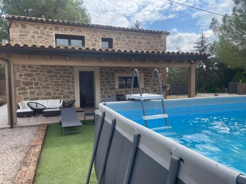 eine Villa mit einem Swimmingpool vor einem Haus in der Unterkunft Cabana Blanca Turisme Rural in Solsona