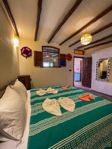 a bedroom with a bed with towels on it at Panorama Guesthouse in Agadir