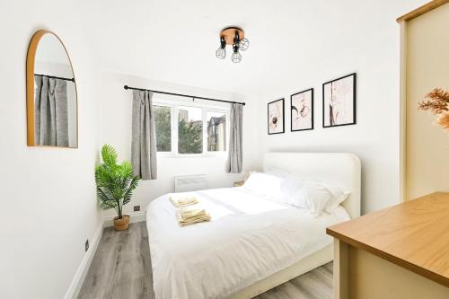 a white bedroom with a bed and a mirror at 1 Bed flat in London with Free Parking in Colindale