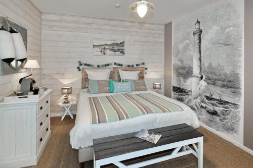 a bedroom with a large bed and a desk at La Maison au-dessus des Voiles in La Baule