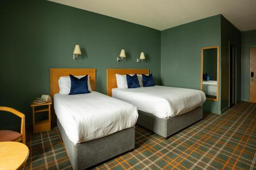 a hotel room with two beds and a table at Portrush Atlantic Hotel in Portrush