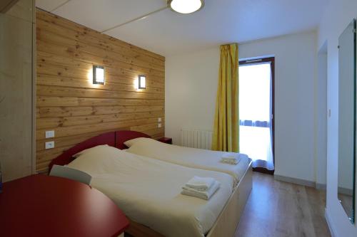 Ένα ή περισσότερα κρεβάτια σε δωμάτιο στο Village Vacances Passion Georges Moustaki