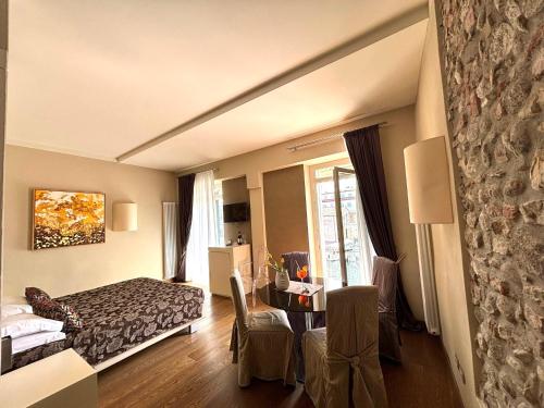 a hotel room with a bed and a table and chairs at Oreste Suite in Lazise