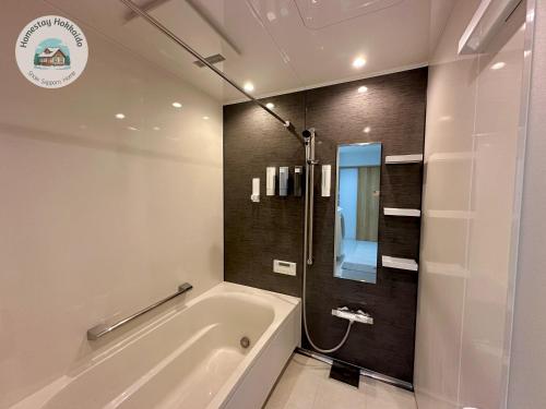a bathroom with a bath tub and a shower at Snow Sapporo Homestay in Sapporo