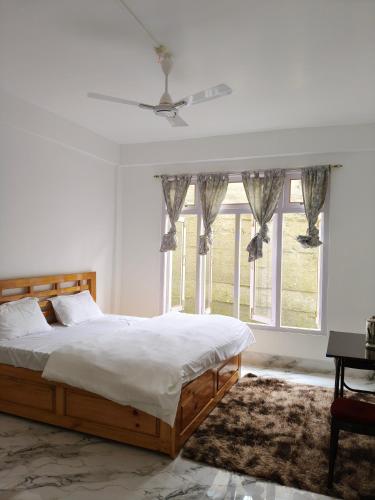 a bedroom with a bed and a large window at Gonpapa Homestay in Dirang Dzong