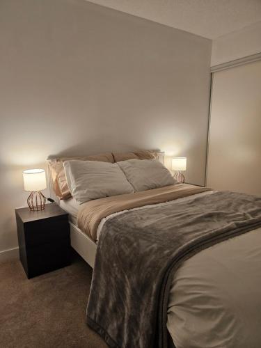 a bedroom with a large bed with two lamps at The Nest in Toronto