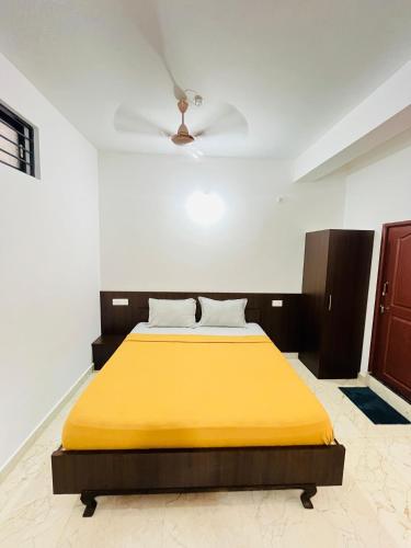 a bedroom with a yellow bed with a ceiling at Nagashree stay inn chickamagalur in Chikmagalūr