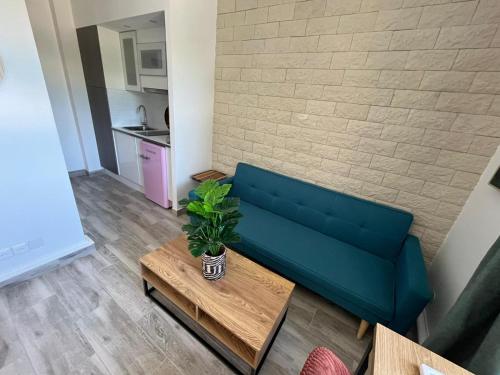 a living room with a blue couch and a table at Le parc d'eden in Villeneuve-sous-Dammartin