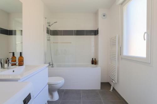 a white bathroom with a toilet and a sink at Maisonnette Stella Plage Terrasse WIFI in Cucq