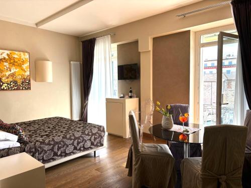a bedroom with a bed and a living room with a table at Oreste Suite in Lazise