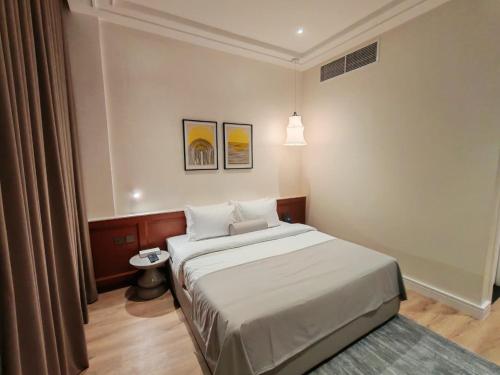 a bedroom with a large bed in a room at Baithans 24 Furnished Apartments Hotel LLC in Ajman 