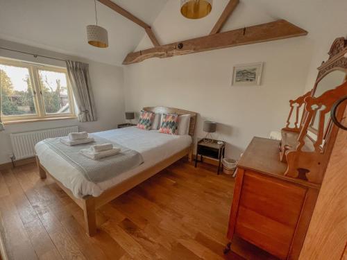 a bedroom with a bed and a wooden floor at Rural Cottage under 3 miles to Mundesley and Norfolk Coast in Knapton