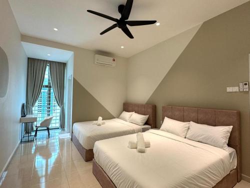 Un dormitorio con dos camas y un ventilador de techo. en RR Muguang Villa, en Melaka