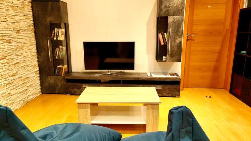 a living room with a table and a tv at Privater Luxus am Untersberg in Grödig
