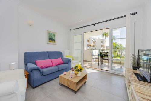 a living room with a blue couch and a table at Apartamento Carabela 51 in Port d'Alcudia