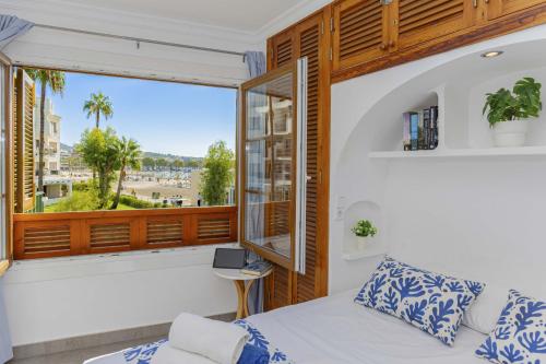 een slaapkamer met een bed en een groot raam bij Apartamento Carabela 51 in Port d'Alcudia