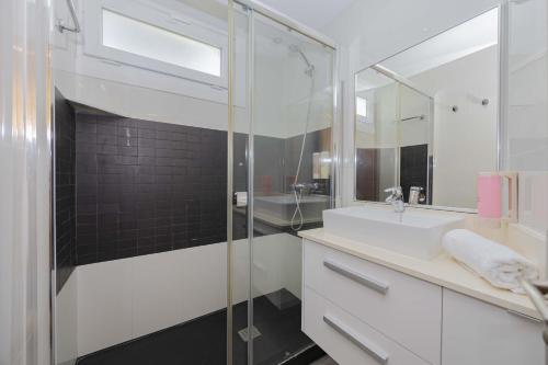 een badkamer met een glazen douche en een wastafel bij Apartamento Carabela 51 in Port d'Alcudia