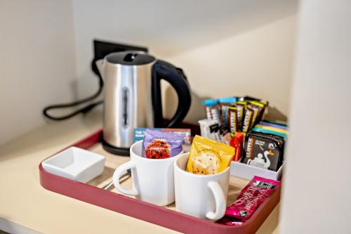 a shelf with two coffee cups and a tea kettle at Cub Bedroom Two in Eastdean