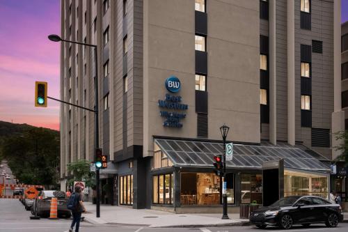 a person crossing a street in front of a building at Best Western Ville-Marie Montreal Hotel & Suites in Montréal