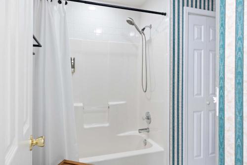 a bathroom with a shower and a white tub at Cookeville Family Retreat 3BR Home with Yard Close to TTU & Town in Cookeville