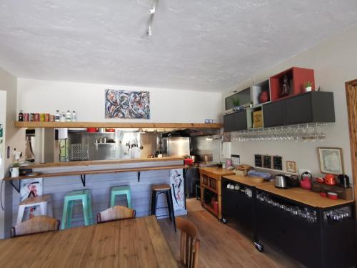 una cocina con encimera y algunas sillas. en Auberge et Gites de Sauze, en Sauze