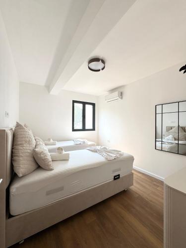a white bedroom with a bed in a room at Moréa Montenegro- Modern, Sea View & Balcony in Krstac