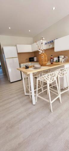 勒格罗-迪鲁瓦Terrasse 4 quai du port de plaisance的厨房配有白色桌子和白色冰箱。