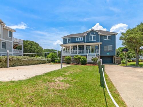 a blue house on the beach with a driveway at 2072 - Laughing Duck in Duck