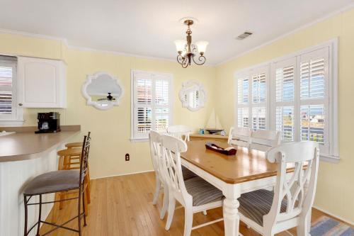 a kitchen and dining room with a table and chairs at 4018 - Shorely Bliss in Kitty Hawk