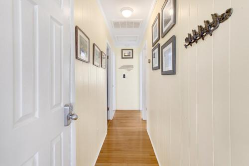a hallway with a white door and pictures on the walls at 4018 - Shorely Bliss in Kitty Hawk