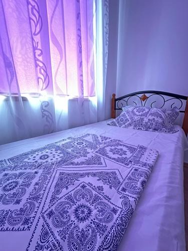 a bed with a blue and white blanket on it at Boulevard Sea Residenz 250 meter zum Sandstrand in Sunny Beach