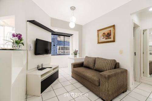un salon avec un canapé et une télévision dans l'établissement Apartamentos a 400 m da Praia em BC - CEV, à Balneário Camboriú