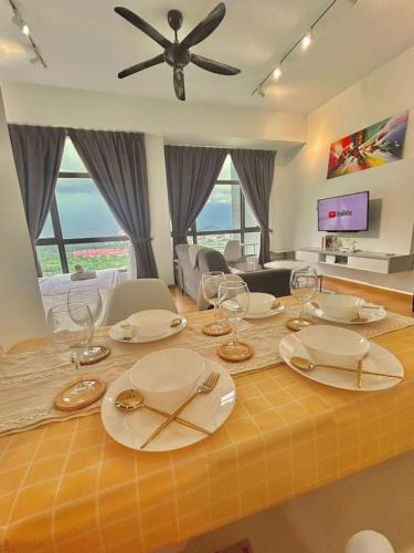 a dining room table with plates and wine glasses on it at imperium residence kuantan in Kuantan