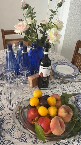 a plate of fruit on a table with a bottle of wine at La Turia Soleada in Cullera