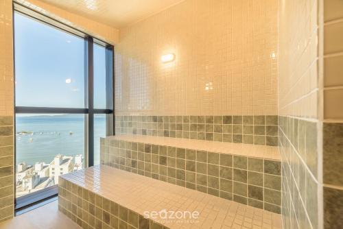 a tiled shower with a view of the ocean at MHF II - Apts Variados em Prédio com Vista para o Mar em Itapema in Itapema