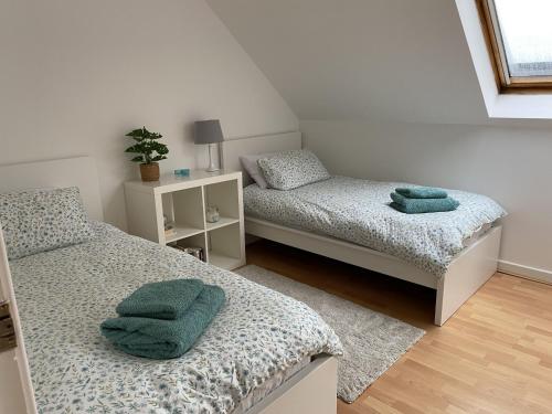 a bedroom with two beds with green towels on them at Skibo Vista Dunfermline in Dunfermline
