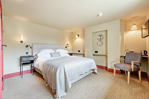 una camera da letto con un letto grande e una sedia di Cub Bedroom Five a Eastdean