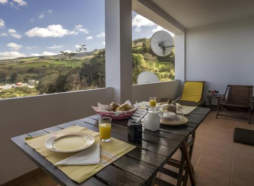 een eetkamer met een tafel en een groot raam bij Beach House - Mountain And Ocean in Ribeira Seca do Porto