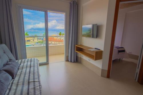 a room with a bed and a window with a view at Pousada Assojuris in Caraguatatuba