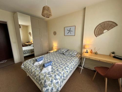- une chambre avec un lit et un bureau dans l'établissement Les Marines-Vue mer & plage Cabourg, à Cabourg